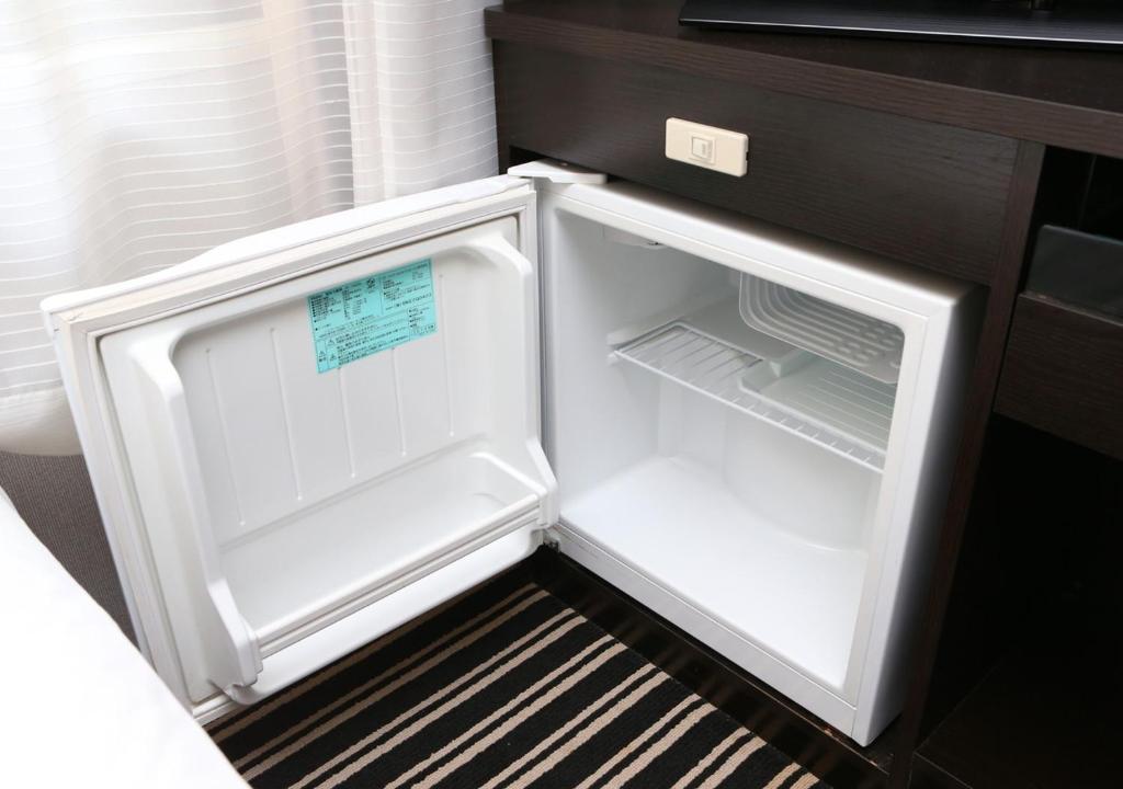 un frigorifero vuoto con la porta aperta in una cucina di APA Hotel Asakusabashi Ekimae a Tokyo
