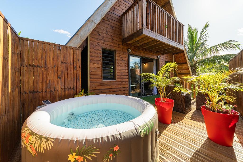 un bain à remous sur la terrasse d'une maison dans l'établissement Charmant chalet avec jacuzzi, L'île Ô Vert, à Saint-Philippe