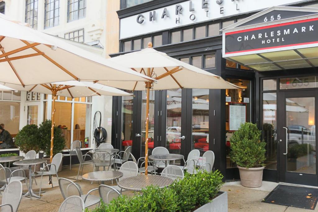 una cafetería al aire libre con mesas, sillas y sombrillas en Charlesmark Hotel, en Boston