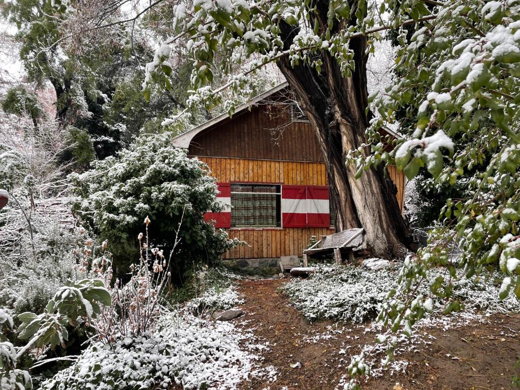 una baita di tronchi con una striscia rossa e bianca sopra di Cabaña de montaña estilo alpino con acceso a Río a Río Blanco