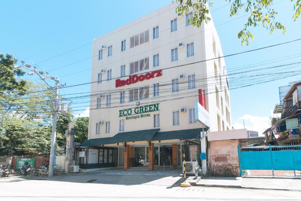 un gran edificio blanco con un letrero verde. en RedDoorz Plus at Eco Green Boutique Hotel, en Davao City