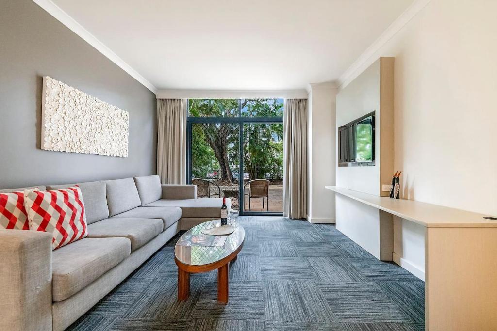 ein Wohnzimmer mit einem Sofa und einem Tisch in der Unterkunft Harbourside Pool Escape with Leafy Alfresco Patio in Darwin