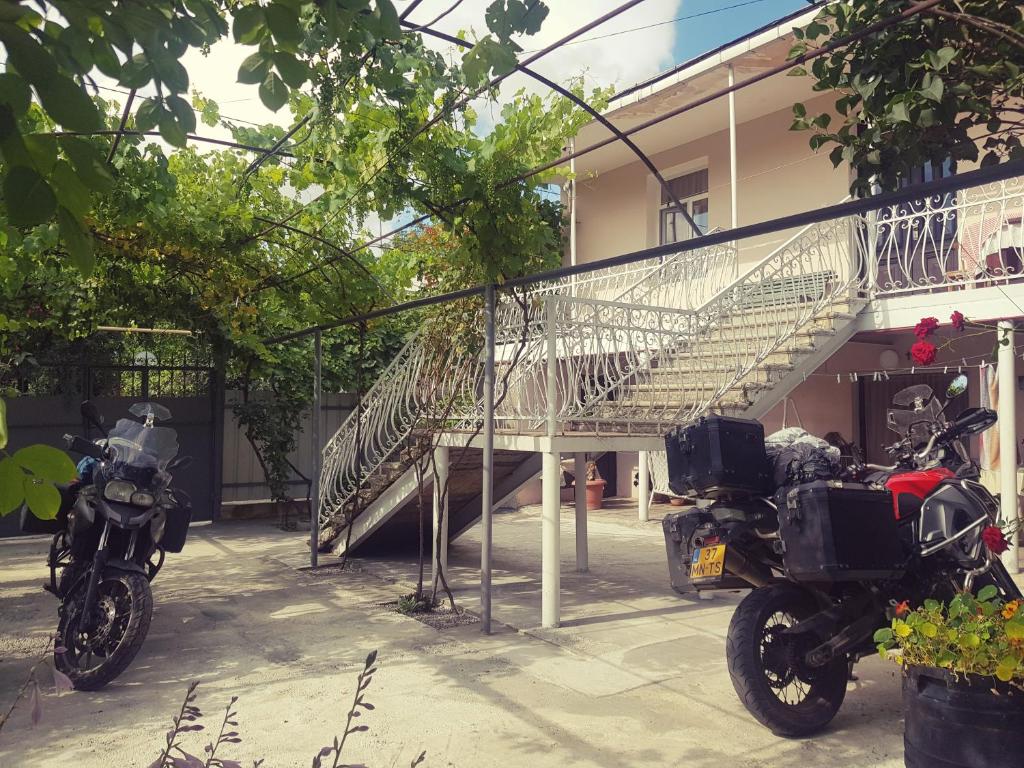 two motorcycles parked next to a building with a staircase at Guest House Adigeni in Adigeni