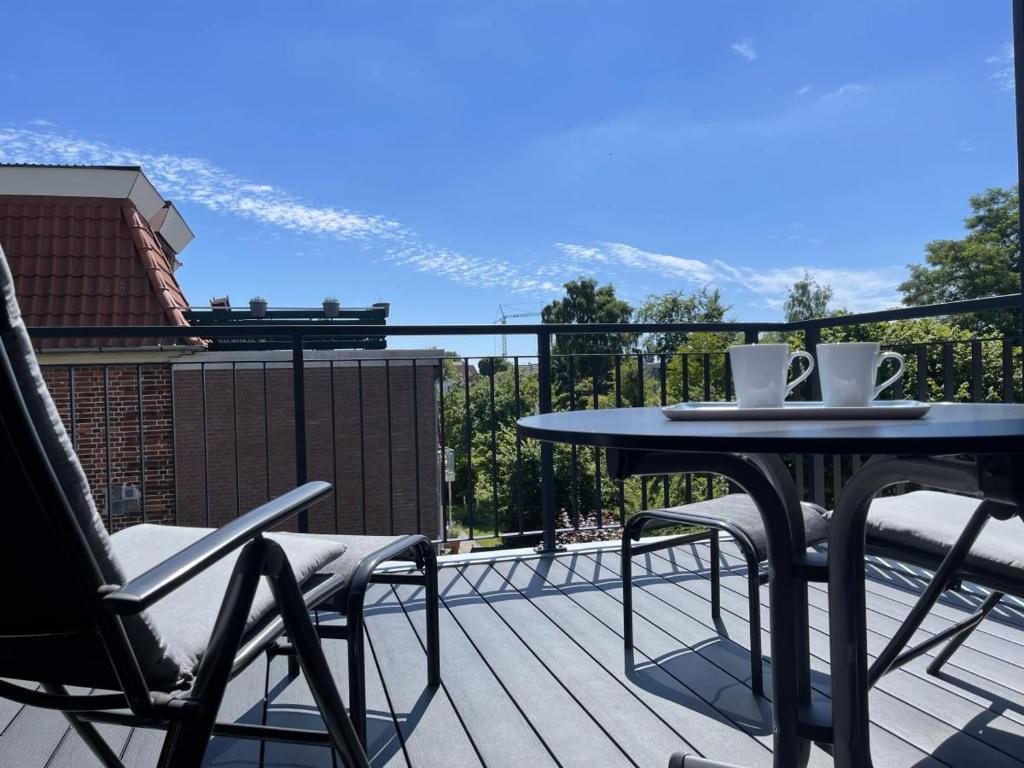 a table and chairs on a balcony with a view at Kellenhusen Tor 24 in Kellenhusen