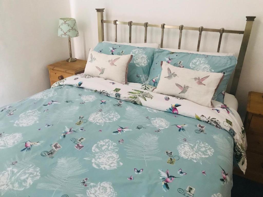 a bed with a blue comforter with butterflies on it at Character Town Centre 1 Bed Flat Boston in Boston