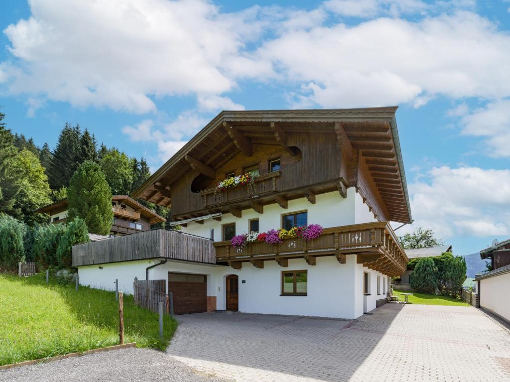 a white house with a wooden roof at Landhaus Brixental in Westendorf