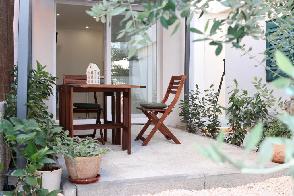 een tafel en stoelen op een veranda met planten bij Lovely Suite in Šibenik