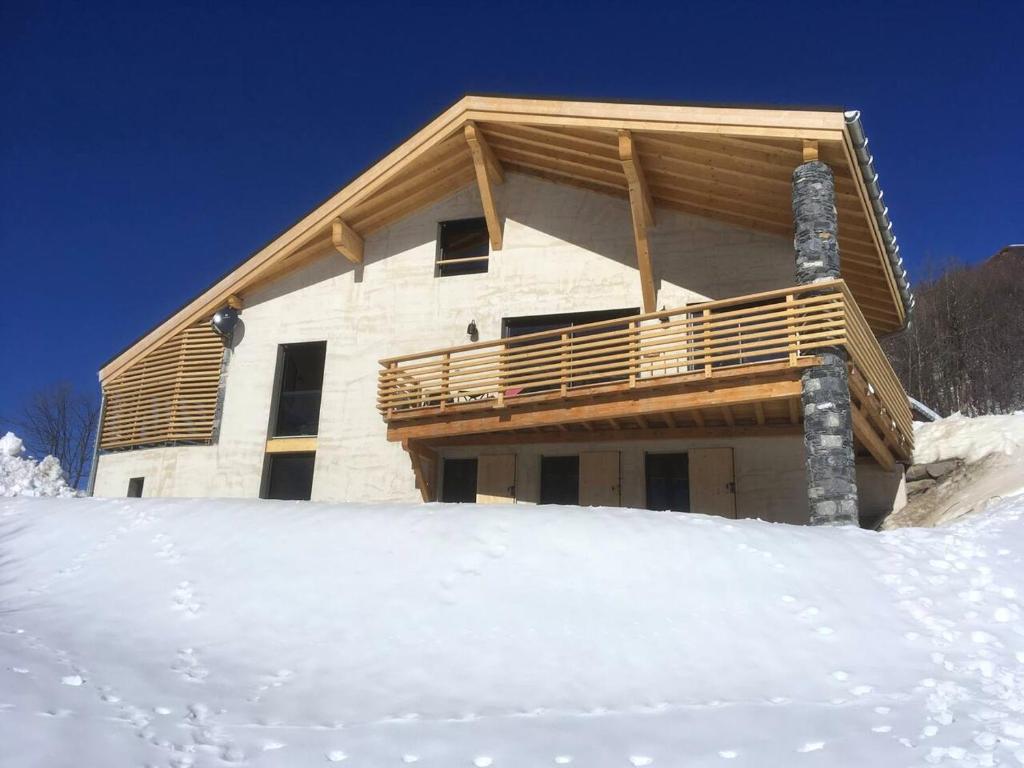 un gran edificio de madera en la nieve con nieve en Chalet de 6 chambres a Valmeinier a 500 m des pistes avec jardin amenage et wifi, en Valmeinier