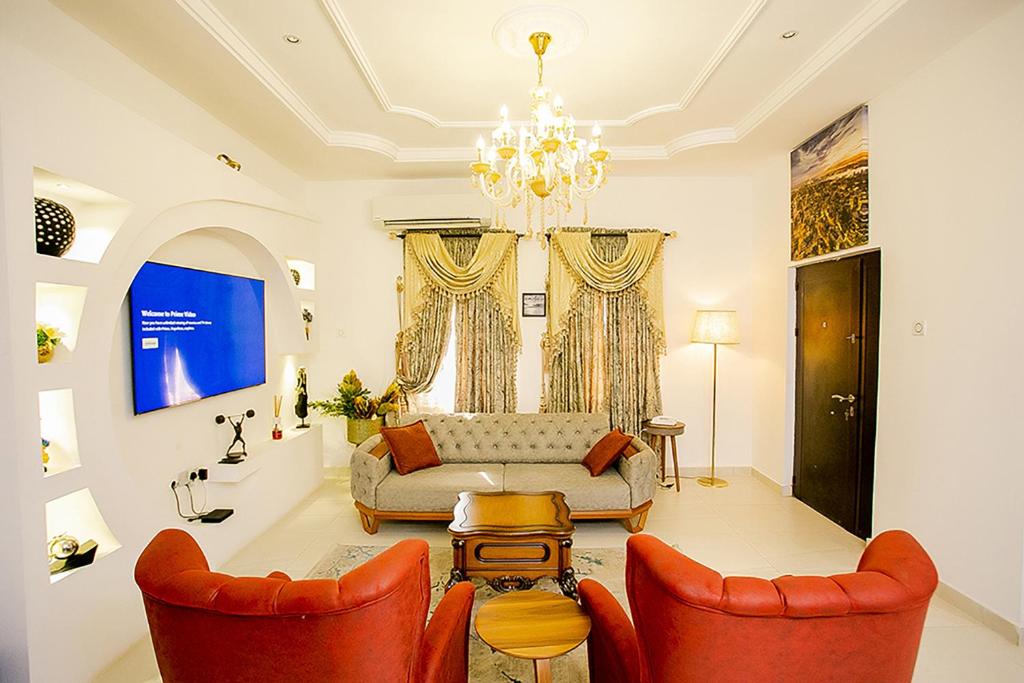 a living room with a couch and two chairs at Kiki's Home and Apartments in Magboro-Akeran