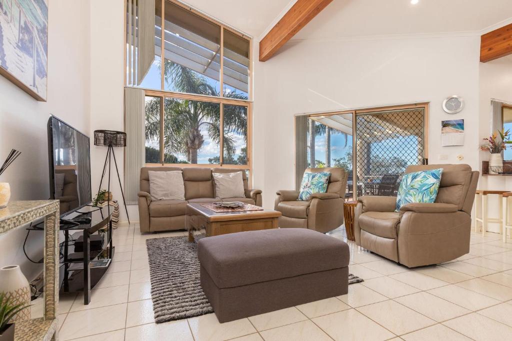 een woonkamer met banken en een tv bij Coral Sands 3 Pebbly Beach in Forster