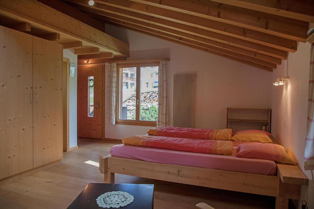 ein Schlafzimmer mit einem großen Bett in einem Zimmer mit einem Fenster in der Unterkunft Landstrasse 153 in Klosters