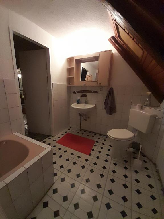 a bathroom with a sink and a toilet and a tub at Ferienwohnung Why Not in Polle