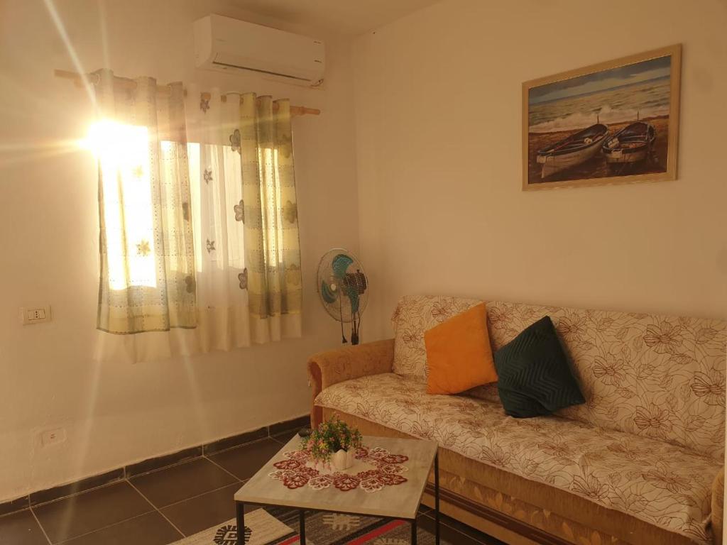 een woonkamer met een bank en een tafel bij Willy Apartments in Velipojë