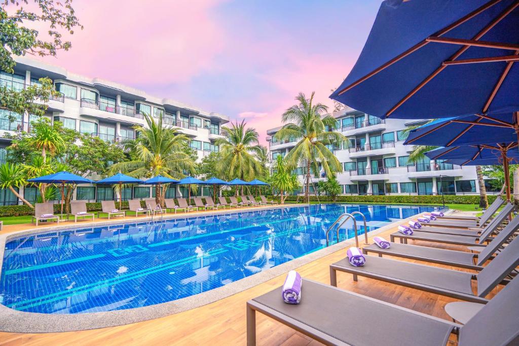 una piscina en un hotel con sillas y sombrillas en Holiday Style Ao Nang Beach Resort, Krabi, en Ao Nang Beach