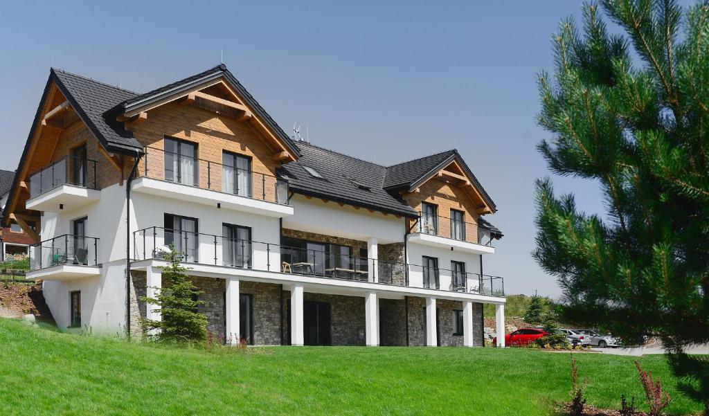 a large house on top of a green hill at Skalnica - Apartamenty w Bieszczadach nad Soliną in Berezka
