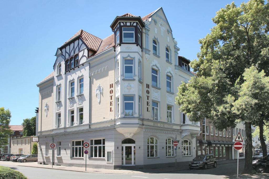 un grand bâtiment blanc au coin d'une rue dans l'établissement Hotel An der Altstadt, à Hameln