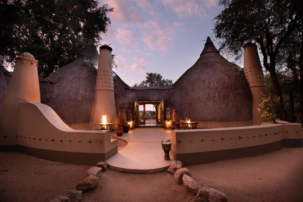 een toegang tot een huis met een gebouw met grasdaken bij Hoyo Hoyo Safari Lodge in Mluwati Concession 