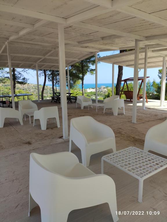 een groep witte stoelen en tafels op een strand bij Residence Carabella in Vieste