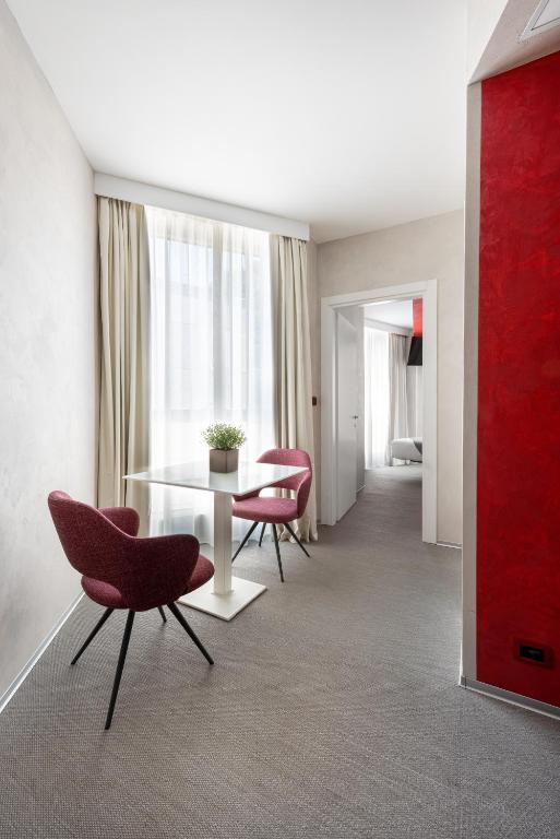 a living room with a table and two chairs and a room at Carrick Hotel Camogli Portofino Coast in Camogli