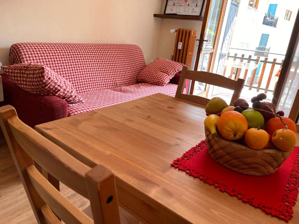 a wooden table with a bowl of fruit on it at Il piccolo rifugio - Casa Valtournenche in Valtournenche