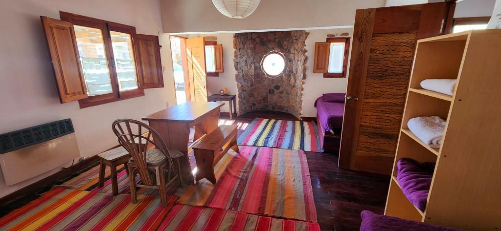 una sala de estar con mesa y una habitación con literas en ETERNO SOL Loft Andino en Humahuaca