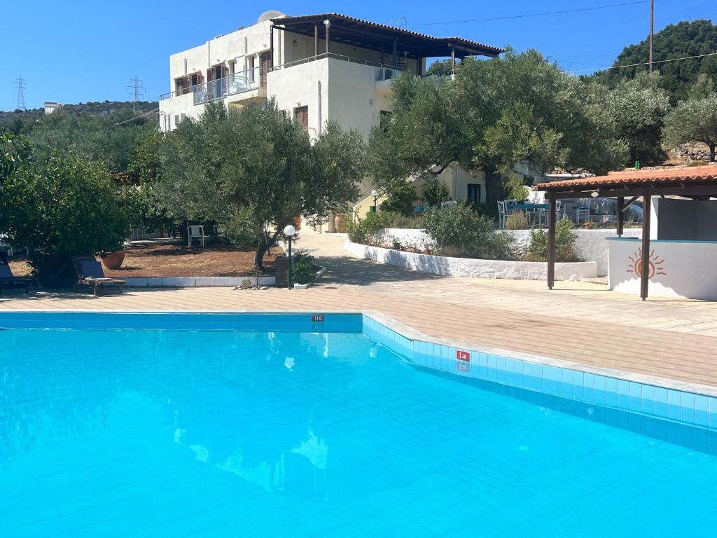 a large blue swimming pool in front of a building at Katerina Charming Place in Agios Nikolaos