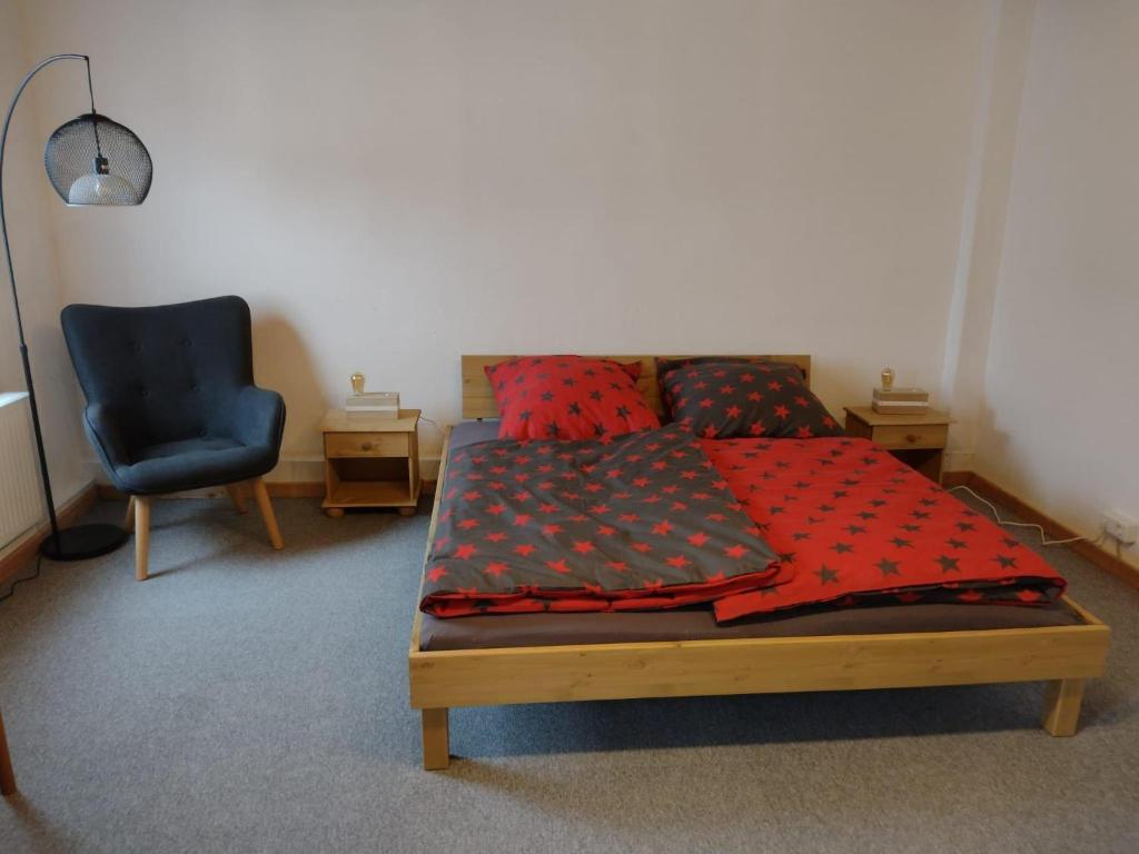 a bedroom with a bed and a blue chair at Ferien-in-ruhiger-Strasse-in-Stadtteil-von-Giessen in Gießen