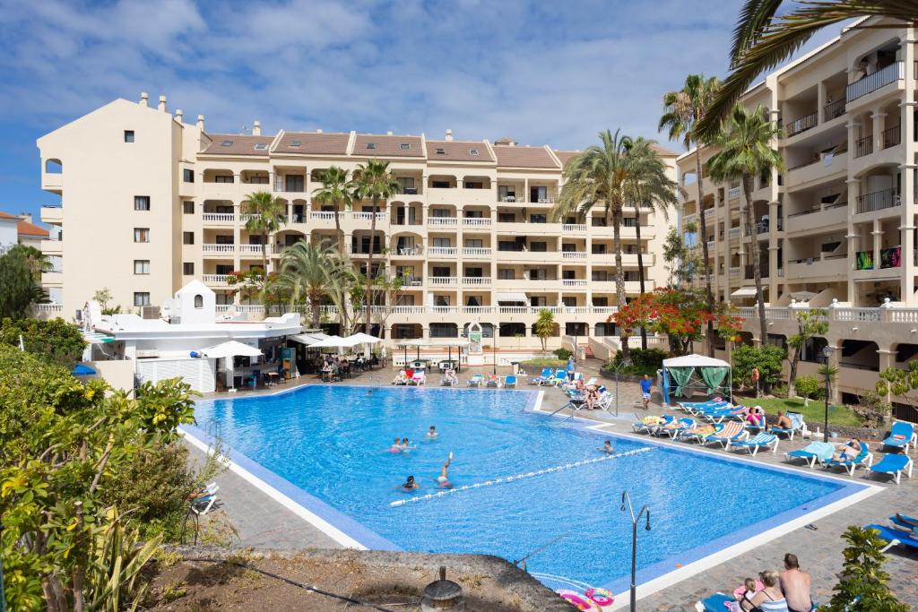 a large swimming pool in front of a hotel at Home2Book Charming Castle Harbour Los Cristianos in Los Cristianos