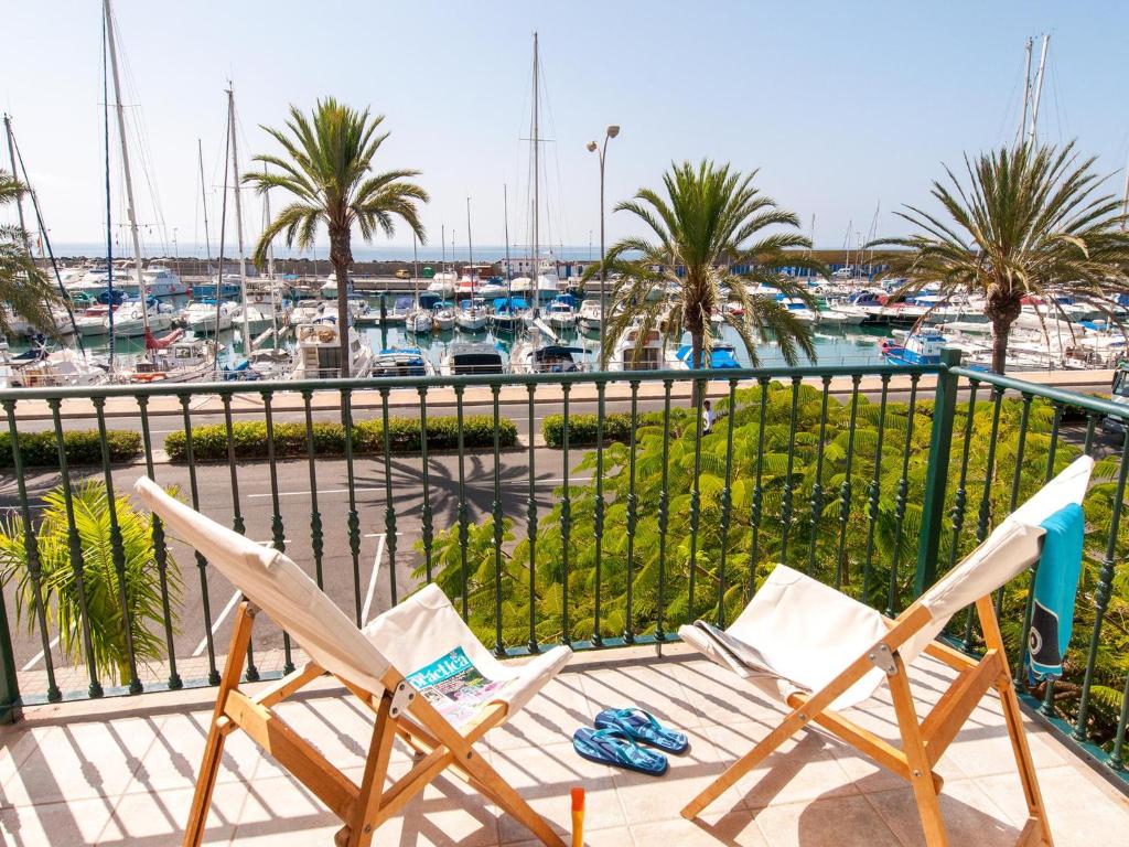 a group of chairs on a balcony with a marina at Bungalow Marina Deluxe in Pasito Blanco