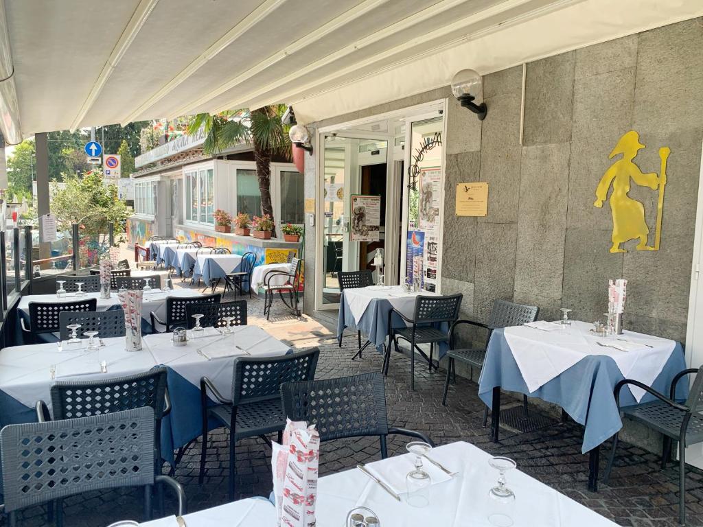 restauracja z białymi stołami i krzesłami przed budynkiem w obiekcie Aquila Nera Di Tony w mieście Ivrea