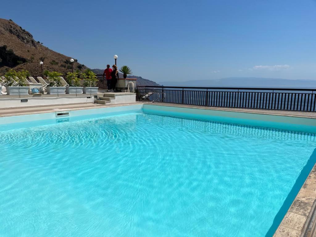 a large blue swimming pool on top of a building at Elisa's House in Taormina
