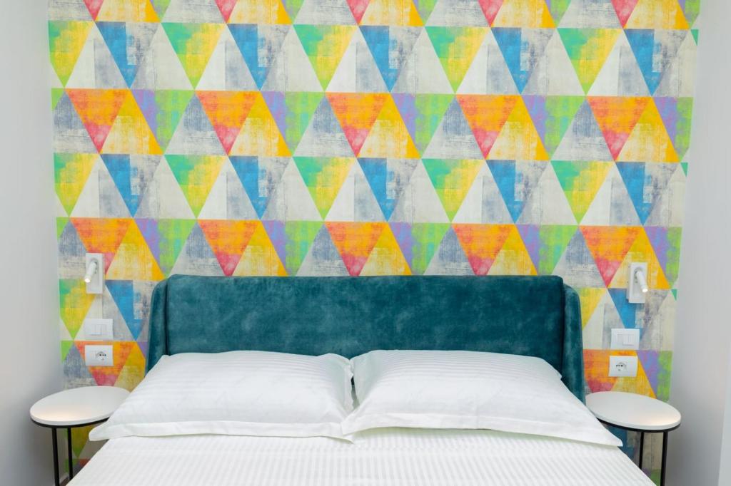 a bedroom with a bed and a colorful wall at Corallo Rooms in Himare