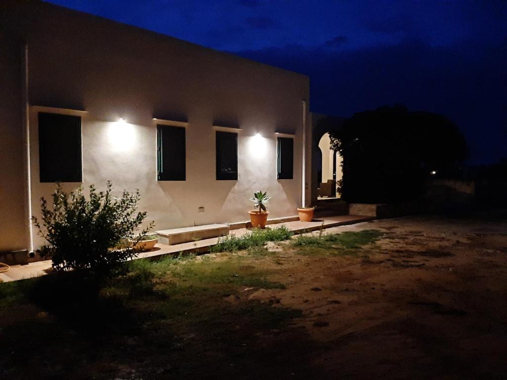 a house with lights on the side of it at night at Gli Archi residence CalaAzzurra in Favignana