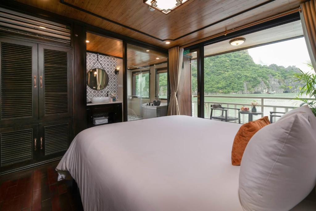a bedroom with a large white bed and a window at Victory Star Cruise in Ha Long