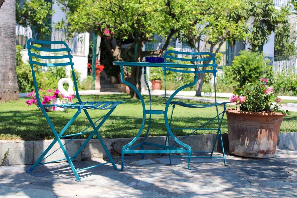 two blue chairs and a table and a table and chairs at Giovanni Group Apartments in Syvota