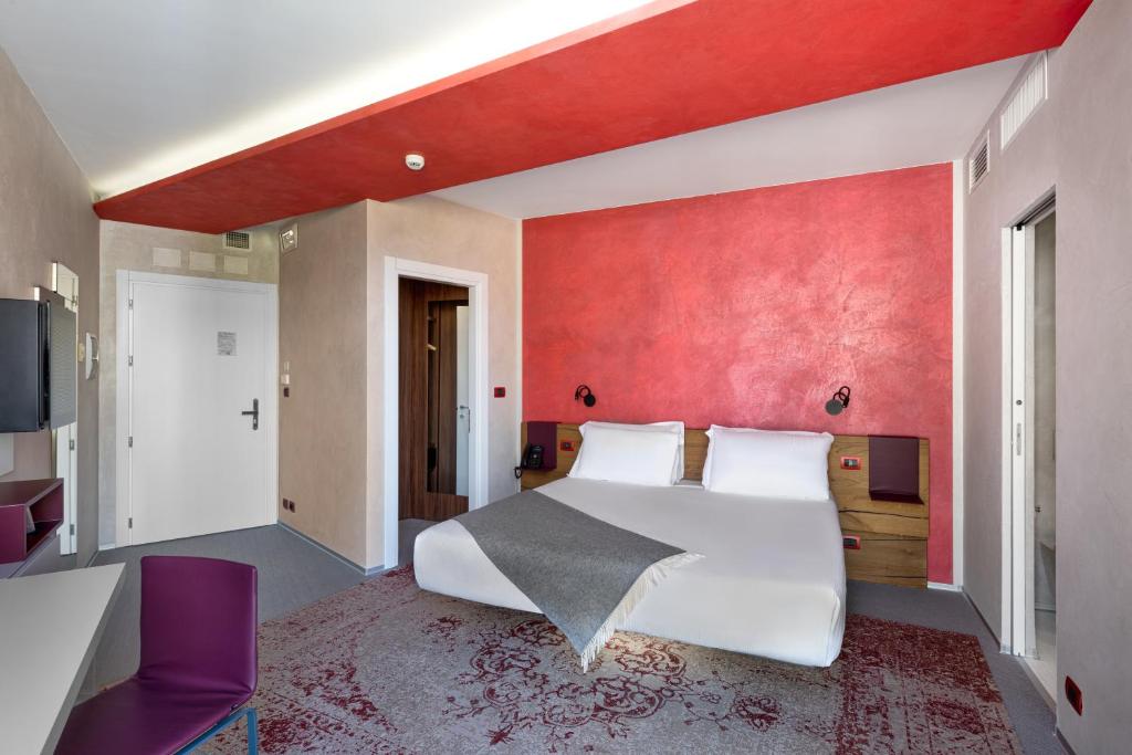 a bedroom with a large bed and a red wall at Carrick Hotel Camogli Portofino Coast in Camogli