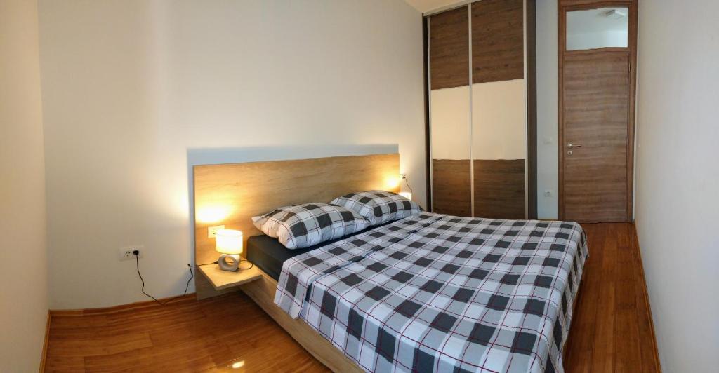 una camera da letto con un letto con una coperta a quadri di West Star Apartment a Trogir