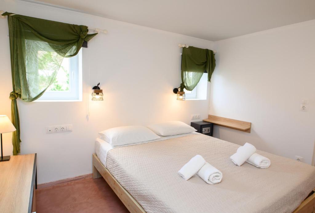 a bedroom with a bed with two towels on it at Lakki Village in Aegiali