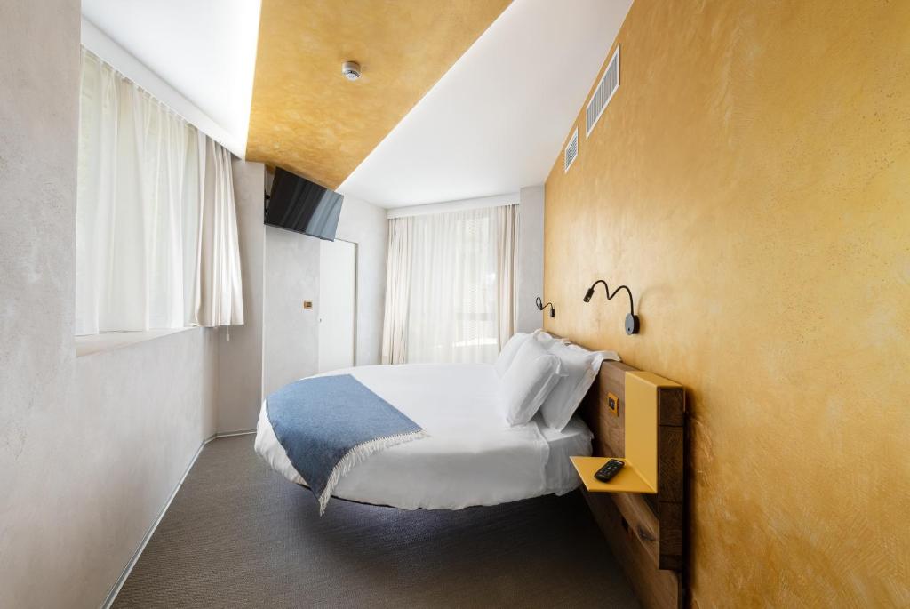 a bedroom with a white bed and a yellow wall at Carrick Hotel Camogli Portofino Coast in Camogli