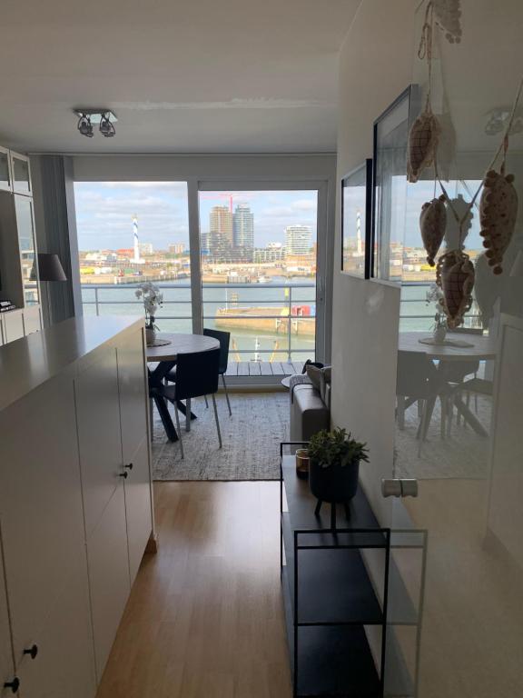 a kitchen and dining room with a view of the city at Oostende Zeezicht Visserskaai in Ostend
