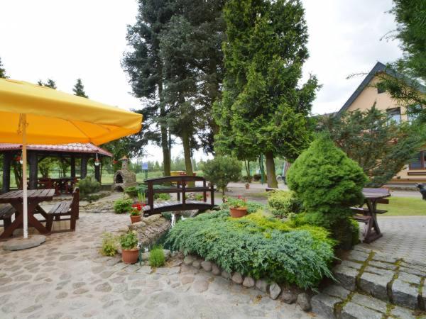 een patio met tafels, banken en planten bij Pokoje Gościnne KORMORAN in Kąty Rybackie