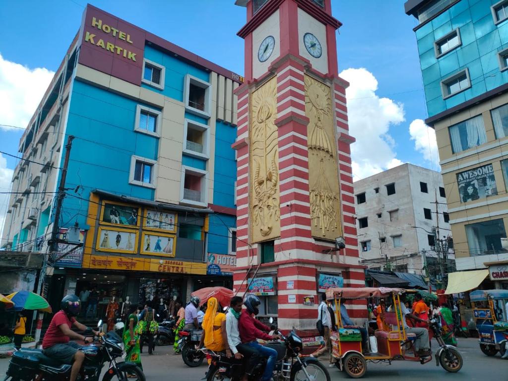 a clock tower in the middle of a busy street at Ditto Room Hotel Kartik, Deoghar in Deoghar