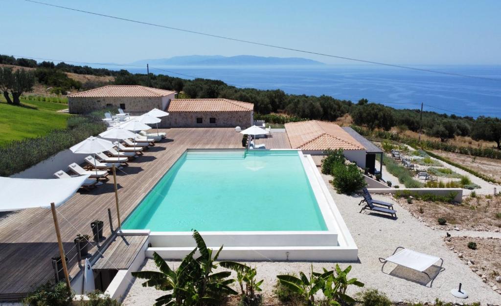 an overhead view of a swimming pool with chairs and umbrellas at KEFI SPITIA in Simotáta