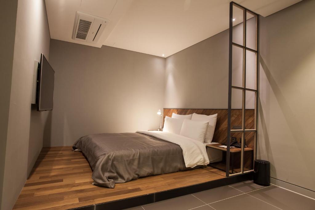 a bedroom with a bed with a glass wall at Hotel Gaden in Suwon