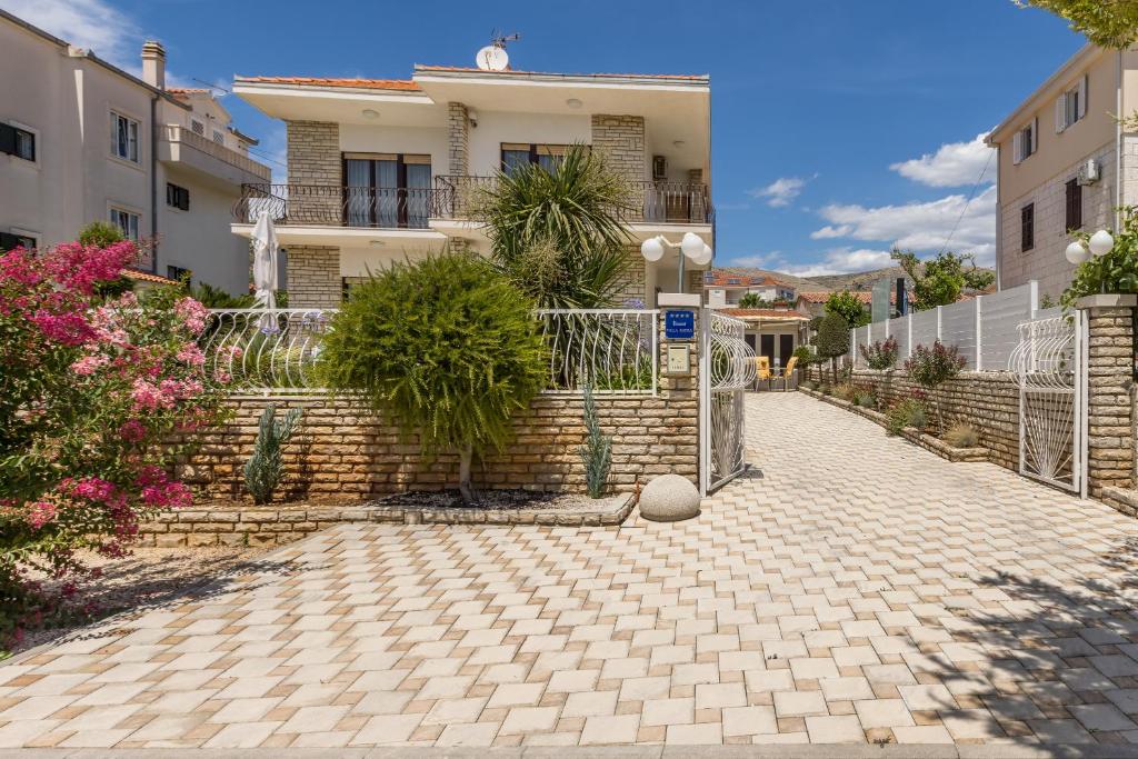 dom z płotem i ceglanym podjazdem w obiekcie Villa Ratka w Trogirze