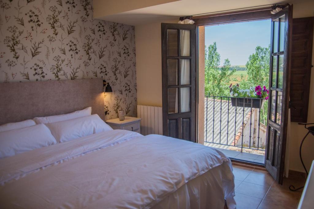 ein Schlafzimmer mit einem Bett und einem großen Fenster in der Unterkunft Posada de Zorita de los Canes in Zorita de los Canes