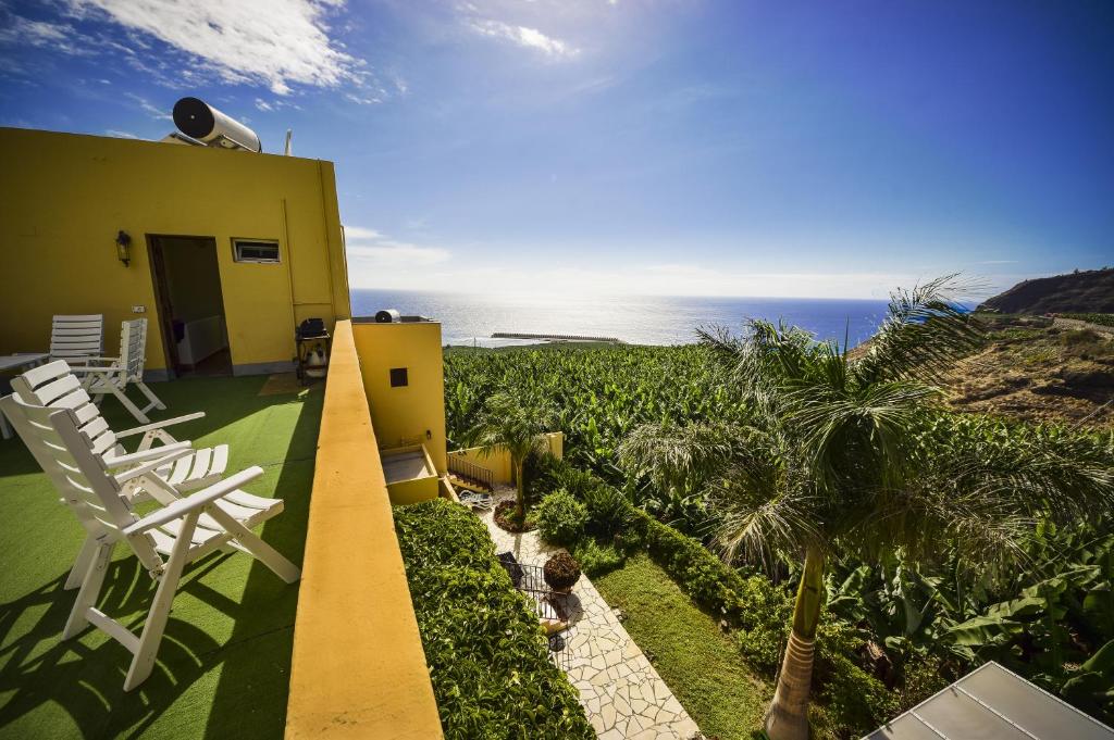 a house with a balcony with a view of the ocean at Apartamentos Finca La Cruz in Tazacorte