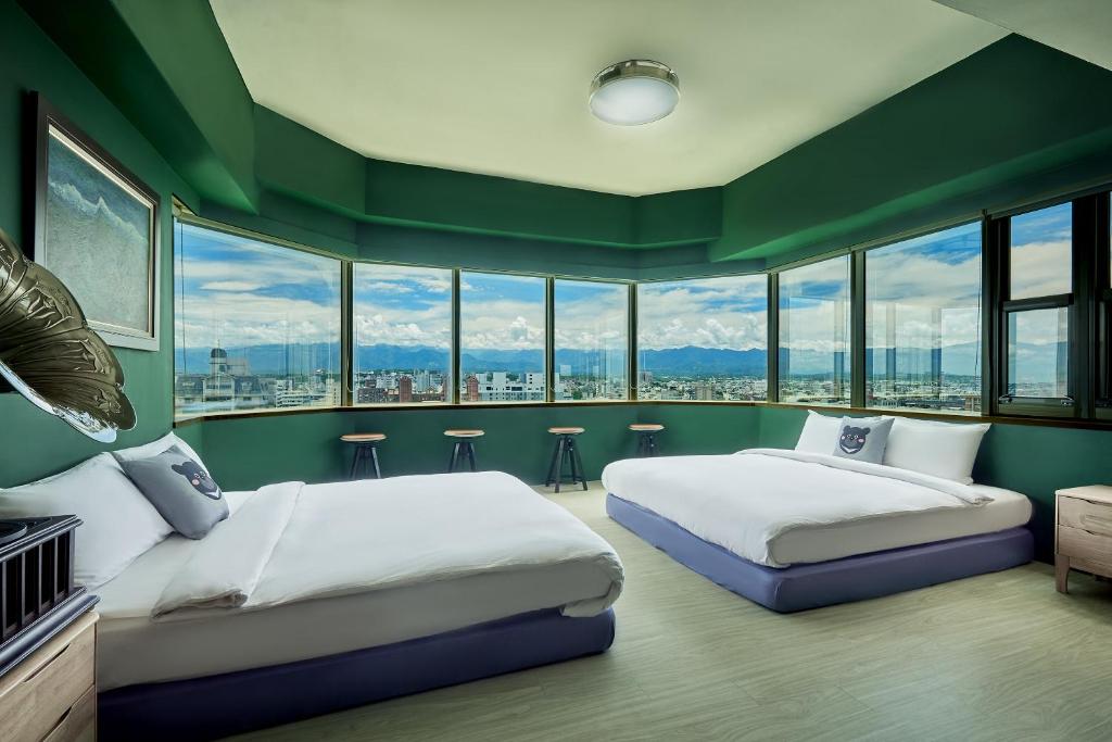 嘉義市的住宿－安蘭居旅店 An Lan Jie Hotel，配有两张床铺的绿色墙壁和窗户