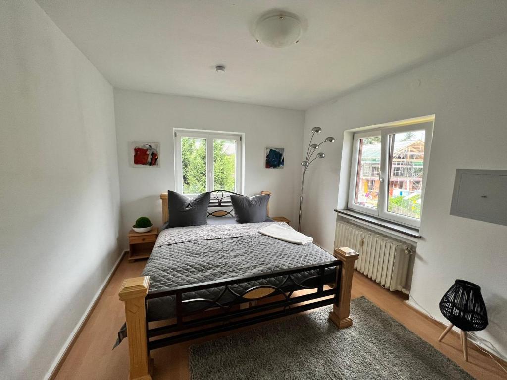 a bedroom with a bed and two windows at Sarah's Zugspitz Inn in Garmisch-Partenkirchen