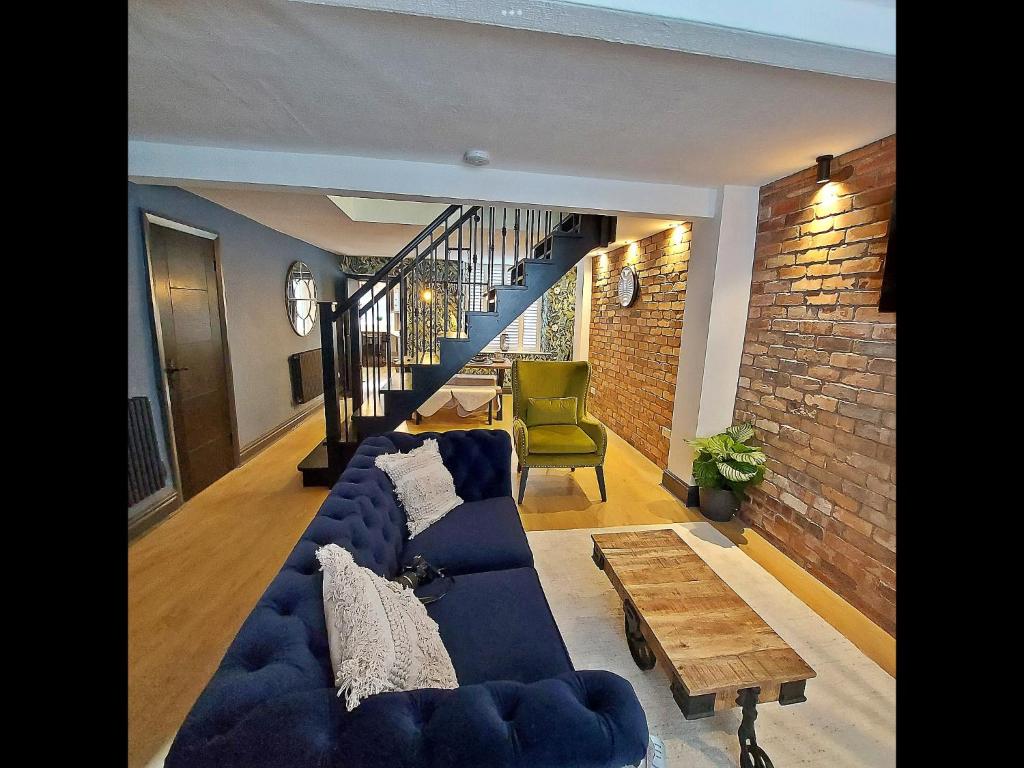 uma sala de estar com um sofá azul e uma mesa em Boutique cottage set in historic town of Clitheroe em Clitheroe